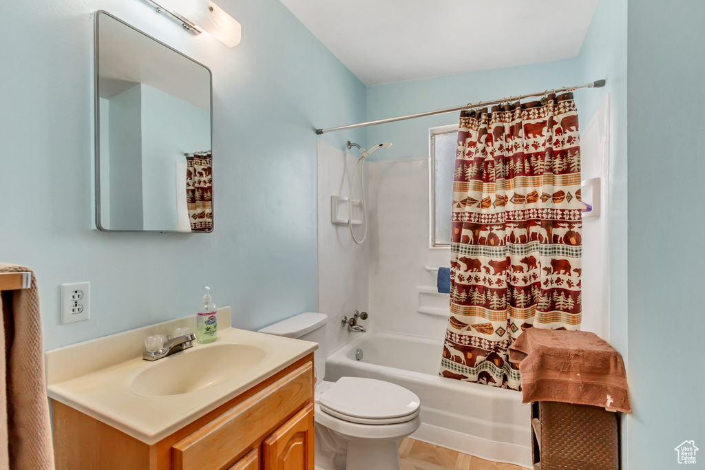 Full bathroom featuring tile flooring, toilet, vanity, and shower / tub combo with curtain