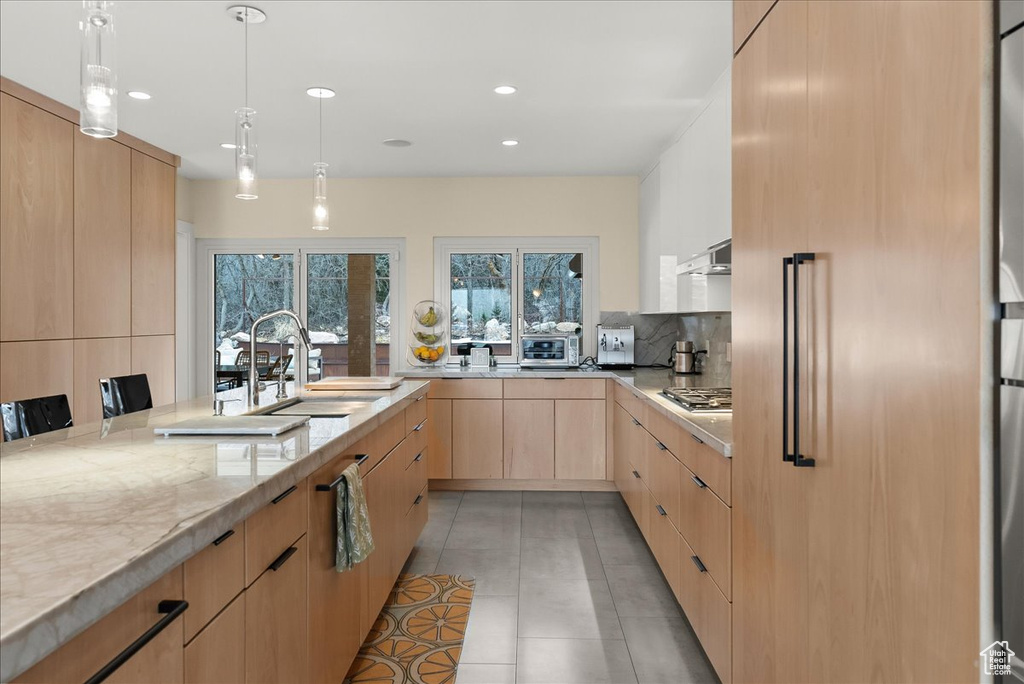 Kitchen featuring sink, pendant lighting, light tile floors, light brown cabinets, and light stone countertops