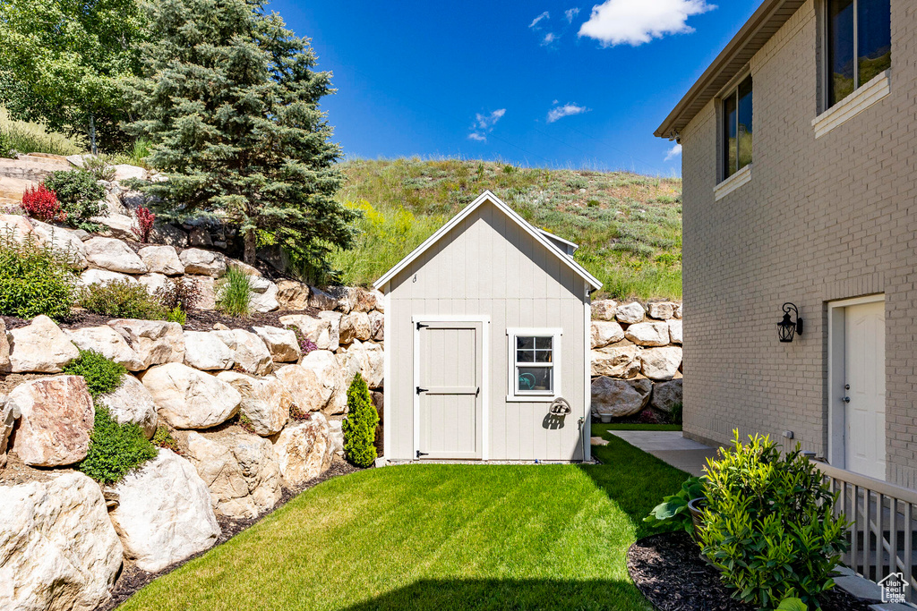 View of outbuilding featuring a lawn