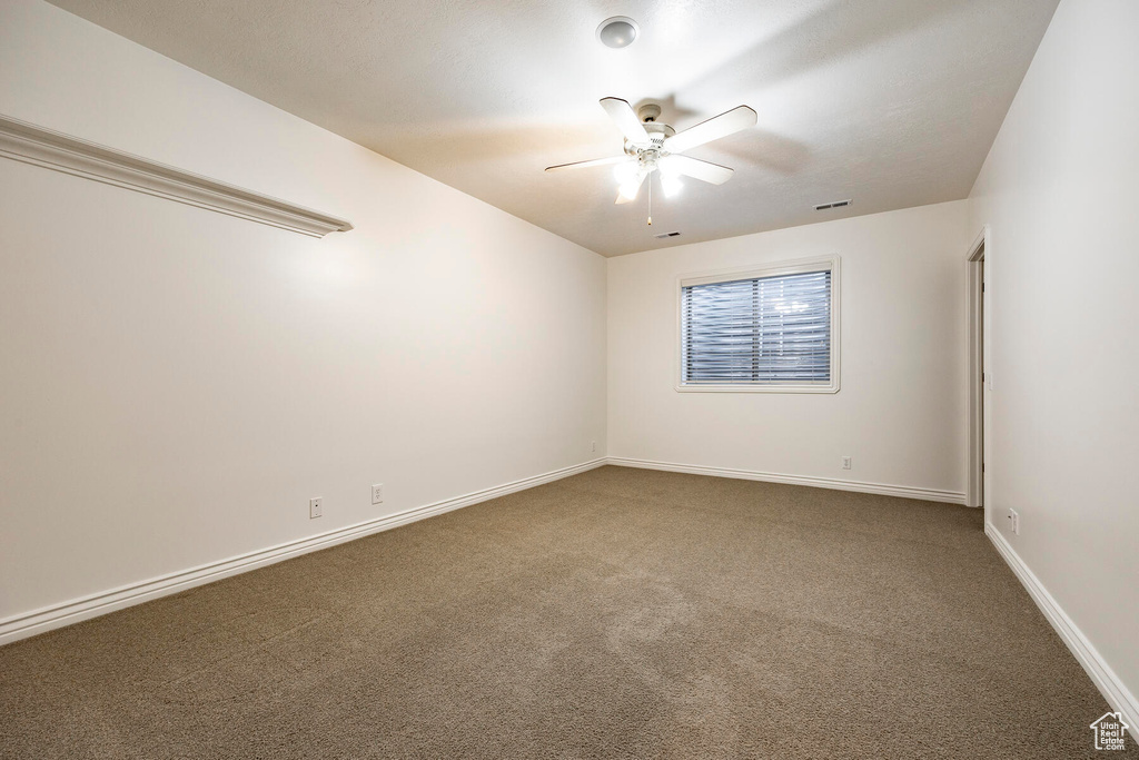 Carpeted spare room with ceiling fan