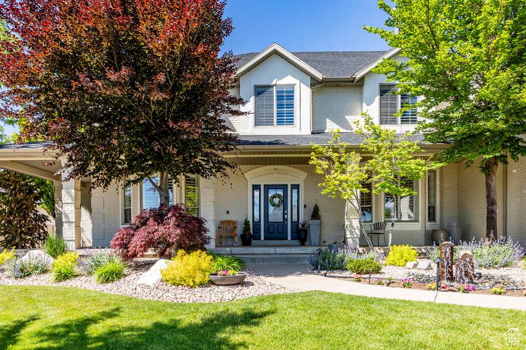 View of front facade with a porch and a front lawn