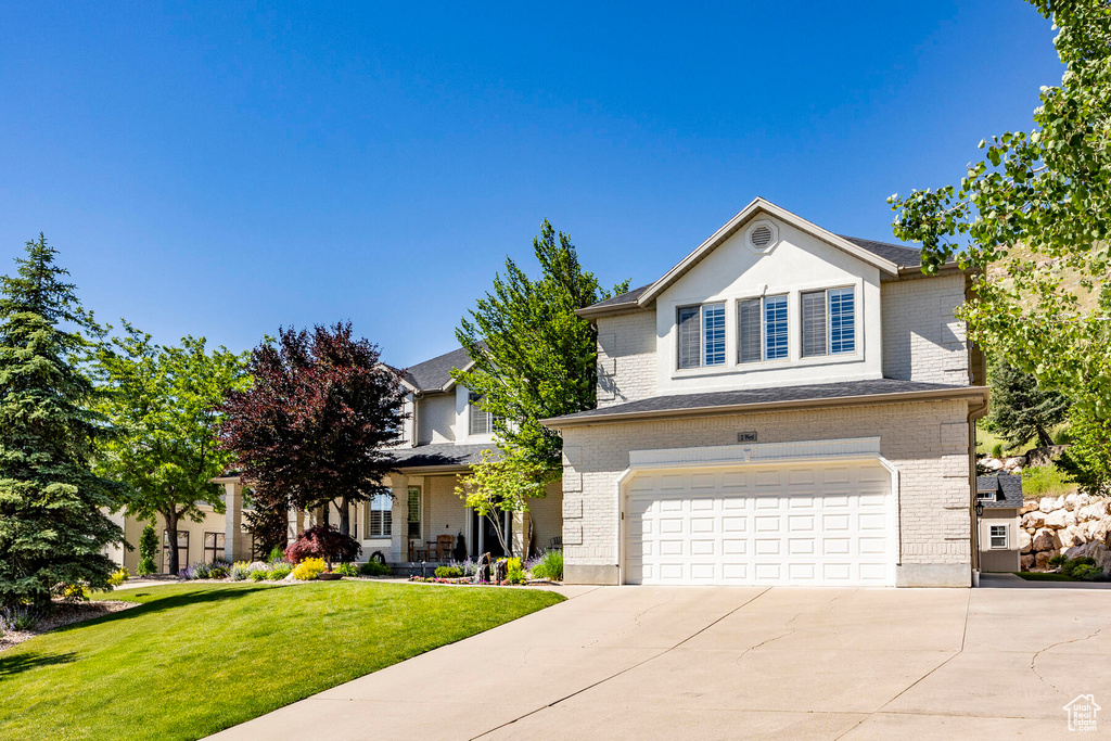 View of front of house featuring a garage and a front lawn