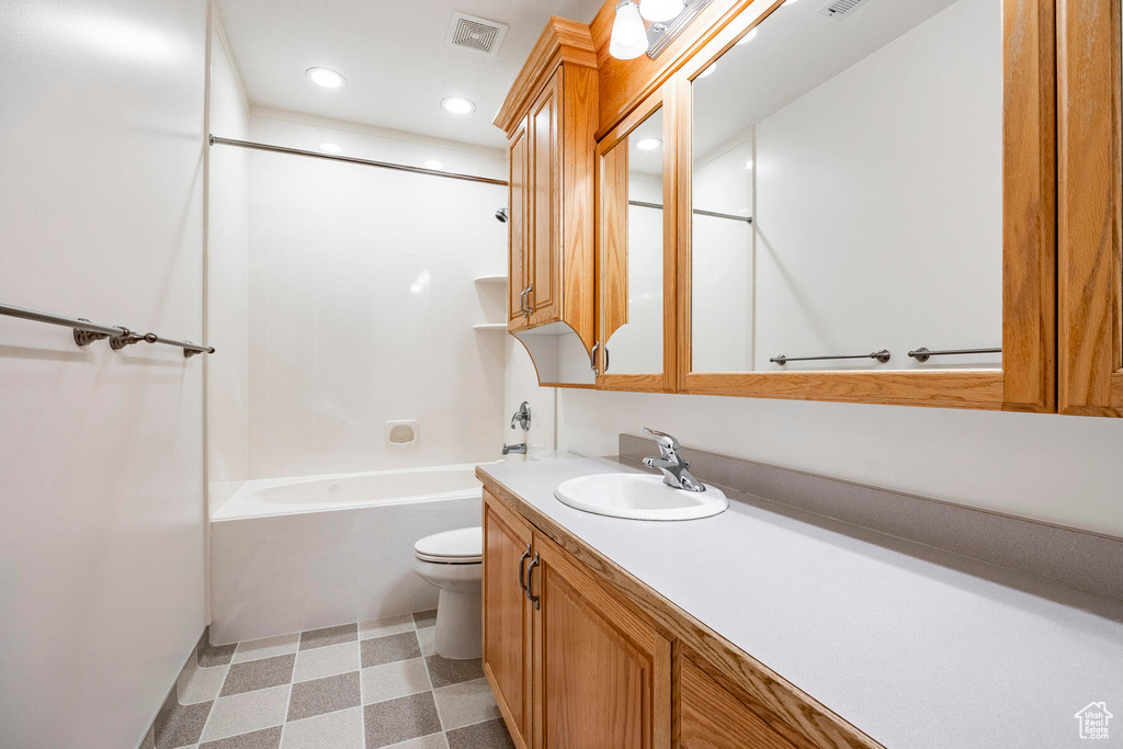 Full bathroom featuring toilet, tub / shower combination, vanity, and tile patterned floors