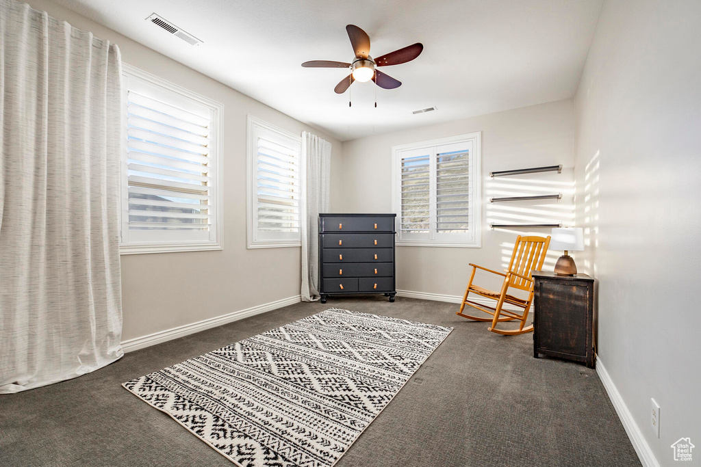 Interior space featuring ceiling fan and dark colored carpet