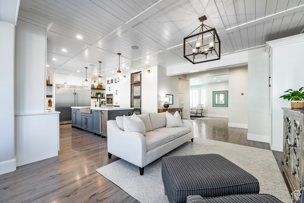 Living room with an inviting chandelier, dark hardwood / wood-style floors, and wood ceiling