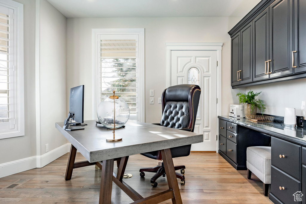 Home office with light hardwood / wood-style floors