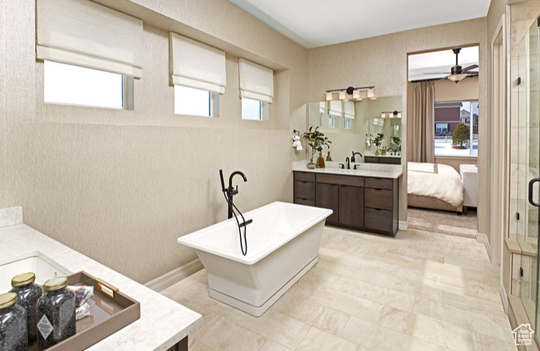 Bathroom with tile flooring, ceiling fan, shower with separate bathtub, and oversized vanity