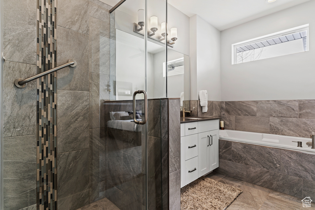 Bathroom featuring vanity, tile flooring, and plus walk in shower