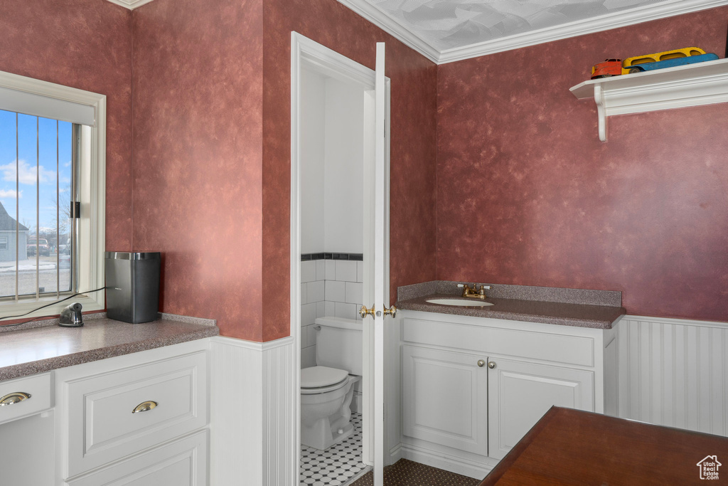 Bathroom featuring tile flooring, crown molding, toilet, and vanity