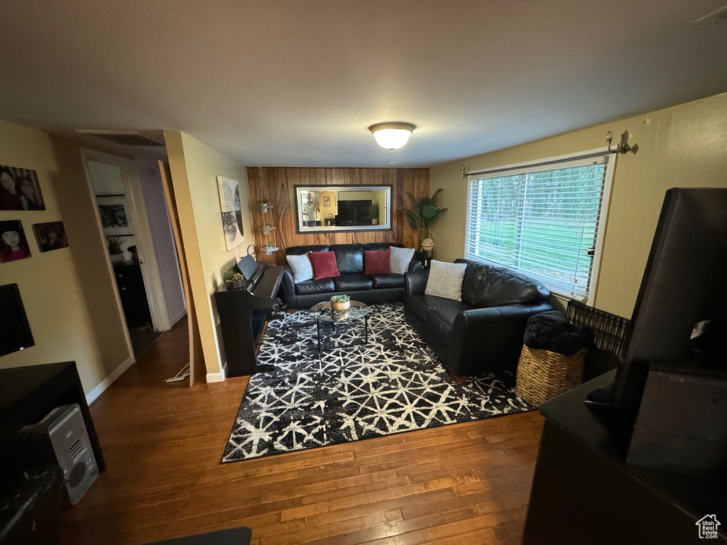 Living room featuring dark hardwood flooring and wooden walls