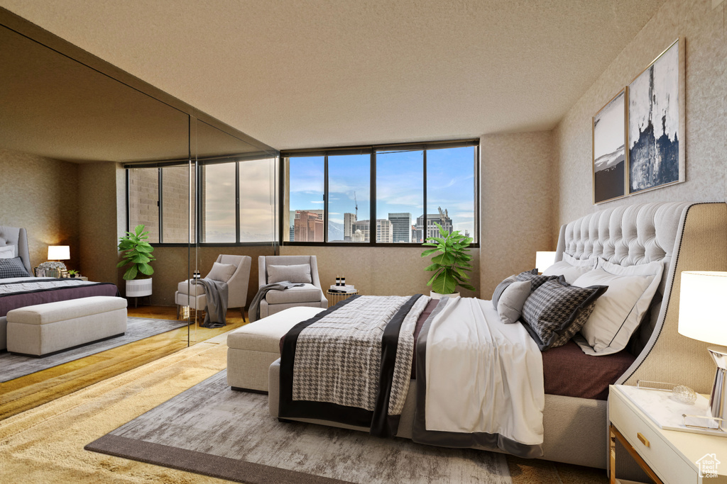 Bedroom with floor to ceiling windows, a textured ceiling, and light hardwood / wood-style flooring