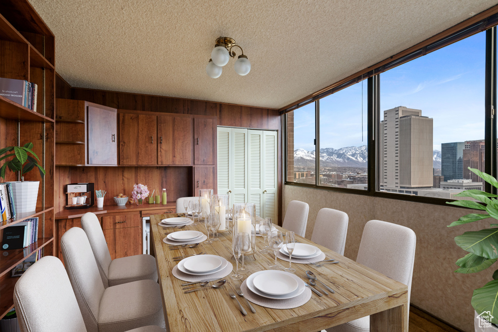 Dining area featuring wooden walls, a mountain view, and a textured ceiling