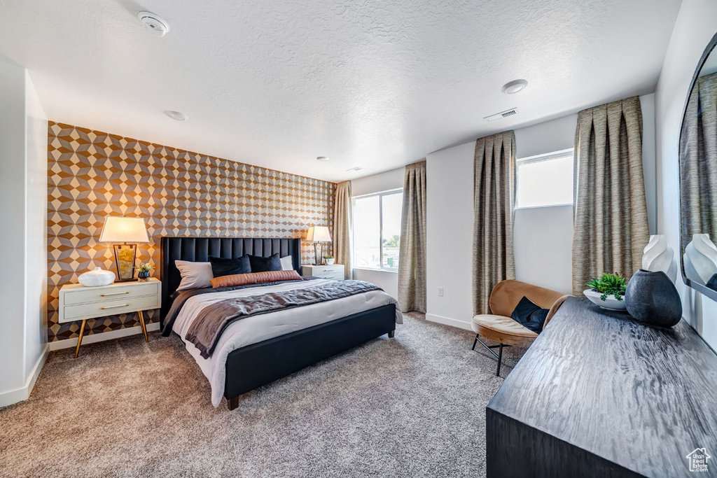 Bedroom with a textured ceiling and carpet flooring