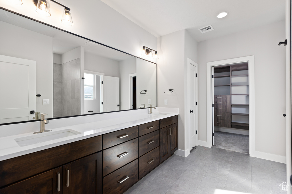 Bathroom featuring tile floors, dual sinks, and large vanity