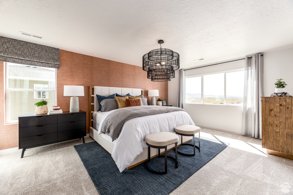 Bedroom featuring a chandelier, a textured ceiling, and light carpet
