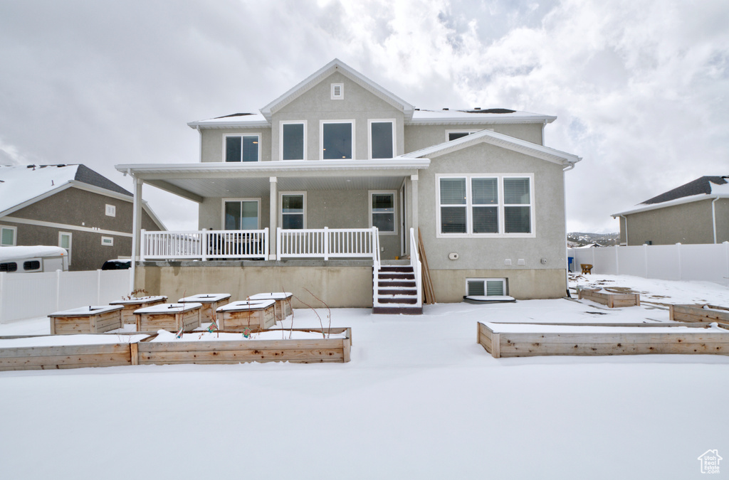 Snow covered rear of property with a patio