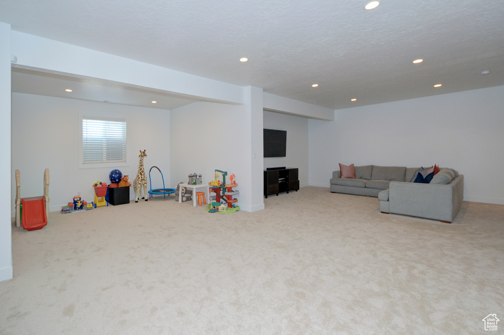 Rec room featuring a textured ceiling and light colored carpet