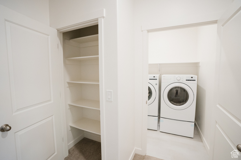 Laundry room featuring light carpet and washing machine and dryer