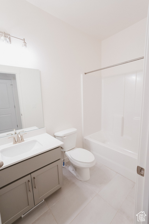 Full bathroom featuring bathtub / shower combination, vanity, tile floors, and toilet