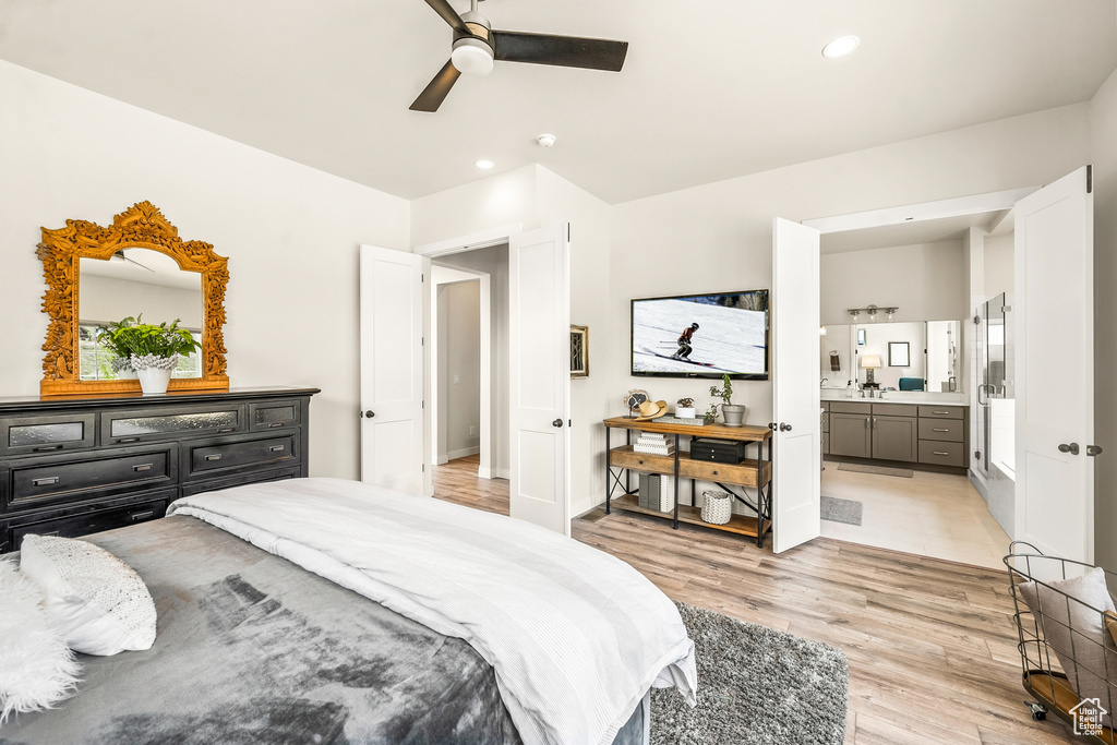 Bedroom featuring ensuite bathroom, ceiling fan, and light hardwood / wood-style flooring