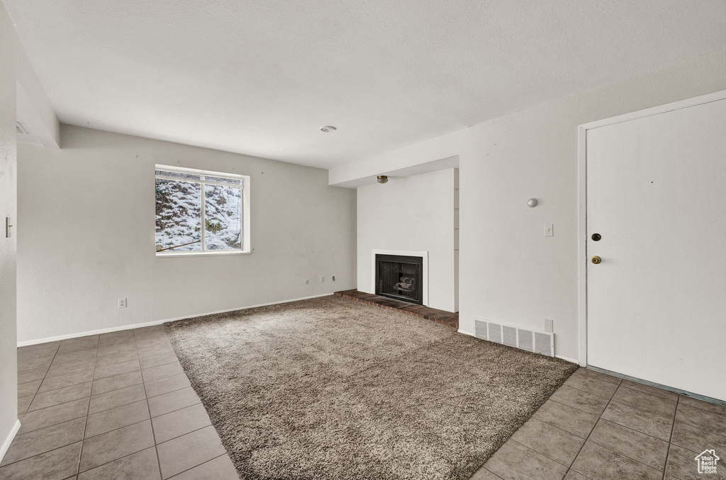 Unfurnished living room featuring tile floors