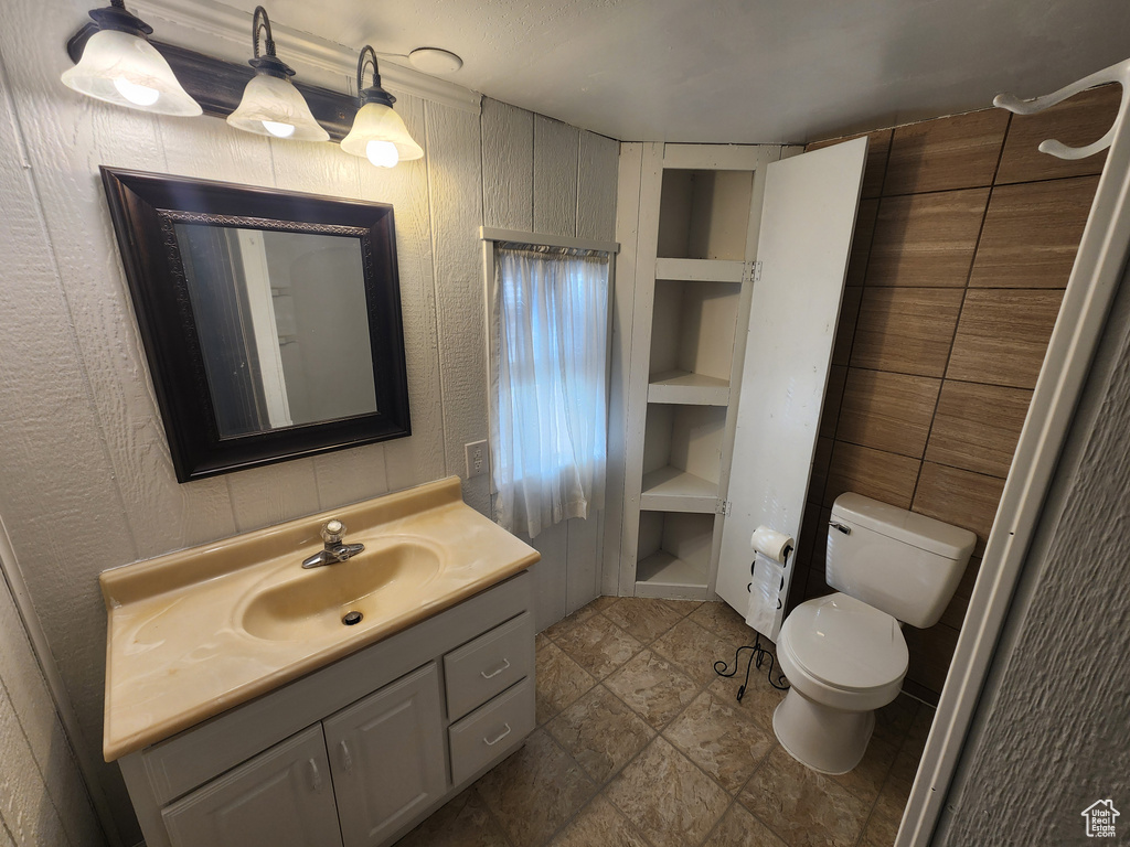 Bathroom featuring tile floors, oversized vanity, built in features, and toilet