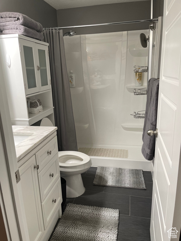 Bathroom featuring vanity, toilet, and a shower with shower curtain