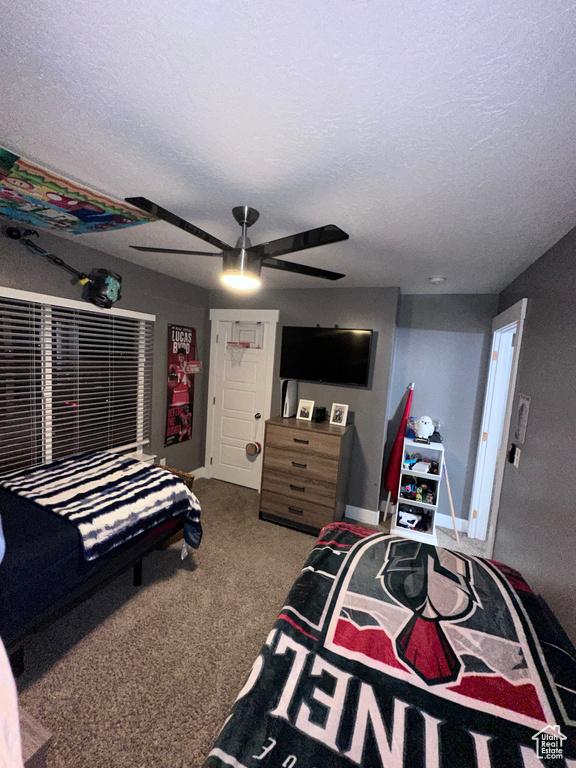 Bedroom featuring carpet floors, a textured ceiling, and ceiling fan