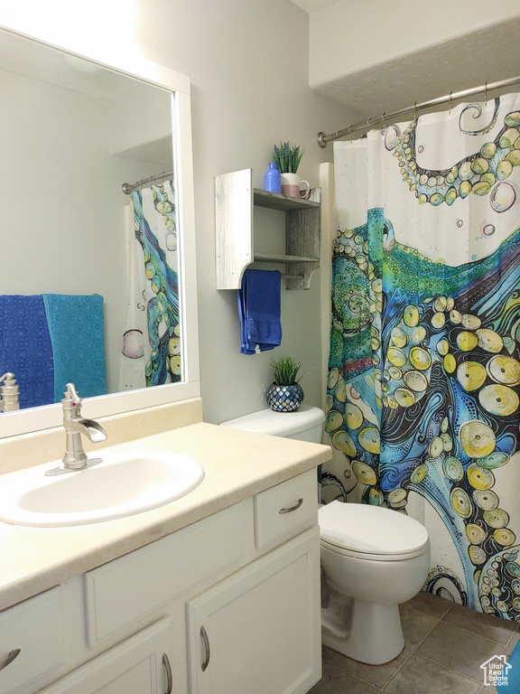 Bathroom featuring toilet, tile flooring, and large vanity