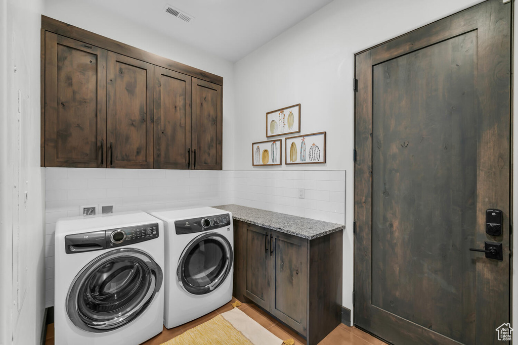 Laundry room featuring cabinets and independent washer and dryer