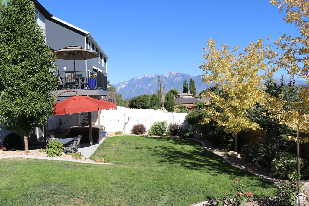 View of yard featuring a patio, a balcony, and a mountain view