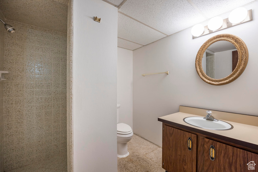 Bathroom featuring a paneled ceiling, vanity, and toilet
