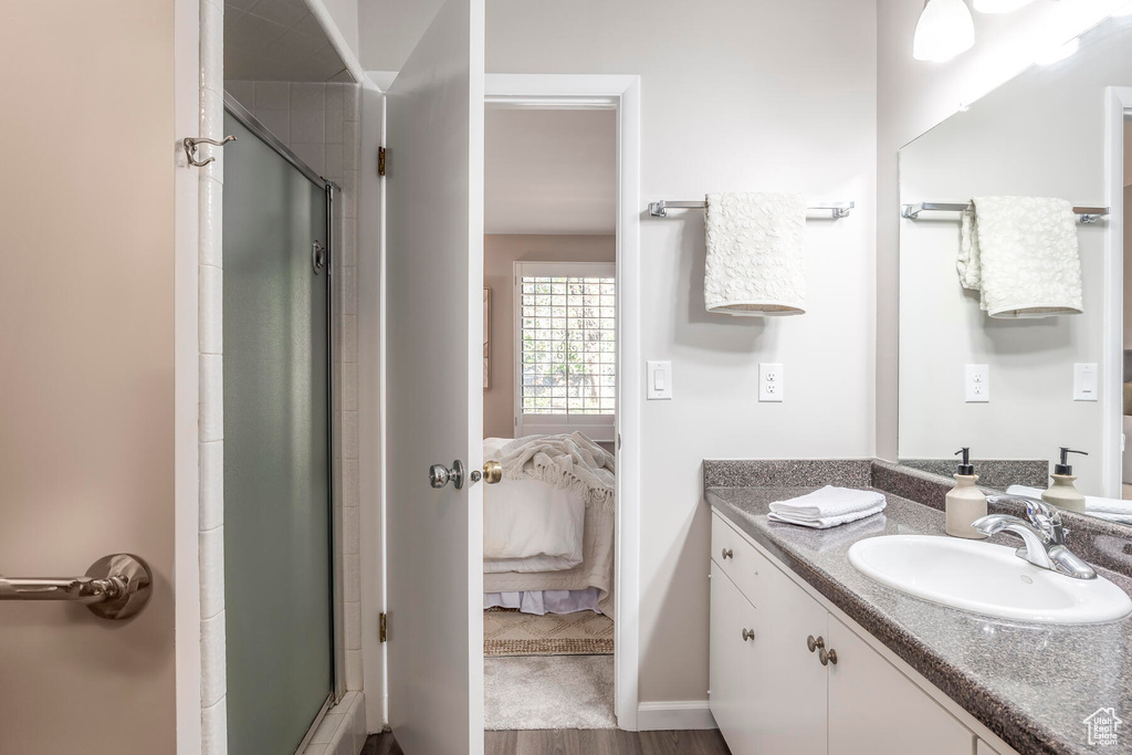Bathroom with walk in shower, hardwood / wood-style floors, and large vanity