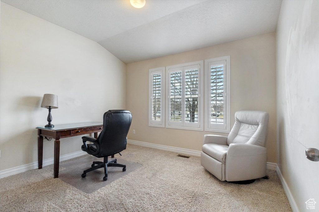 Home office featuring light colored carpet and vaulted ceiling