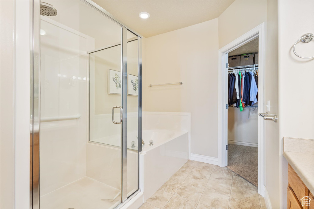 Bathroom featuring tile flooring, separate shower and tub, and vanity