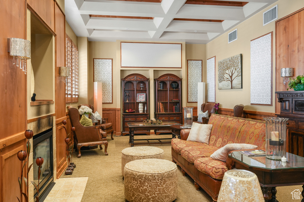 Carpeted living room with coffered ceiling and beam ceiling