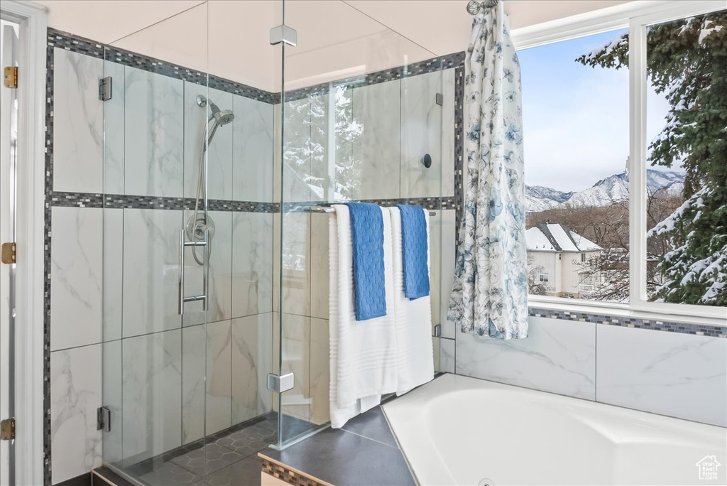 Bathroom featuring shower with separate bathtub and a mountain view