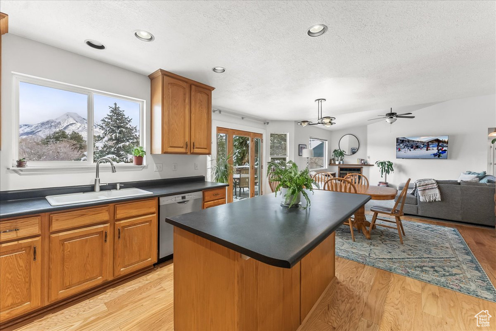 Kitchen featuring a kitchen island, ceiling fan, sink, light hardwood / wood-style flooring, and dishwasher