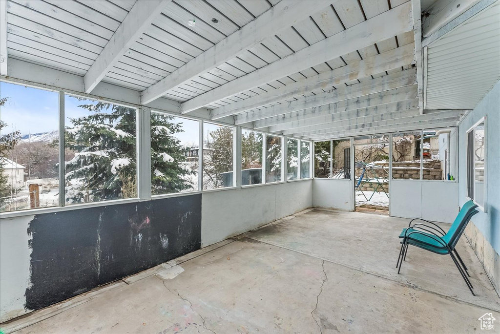 Unfurnished sunroom with beam ceiling