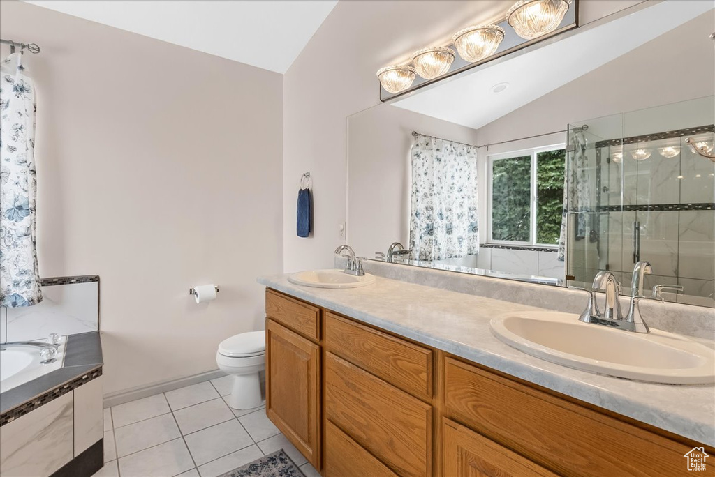 Full bathroom with vaulted ceiling, shower with separate bathtub, toilet, tile flooring, and double vanity