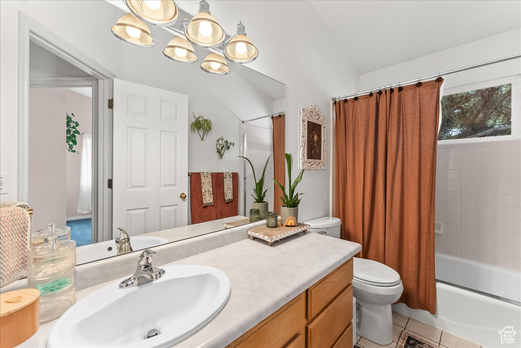 Full bathroom featuring a notable chandelier, toilet, shower / bathtub combination with curtain, tile floors, and large vanity