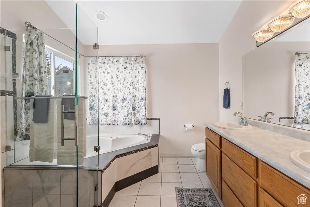 Full bathroom featuring dual vanity, toilet, tile floors, and plus walk in shower