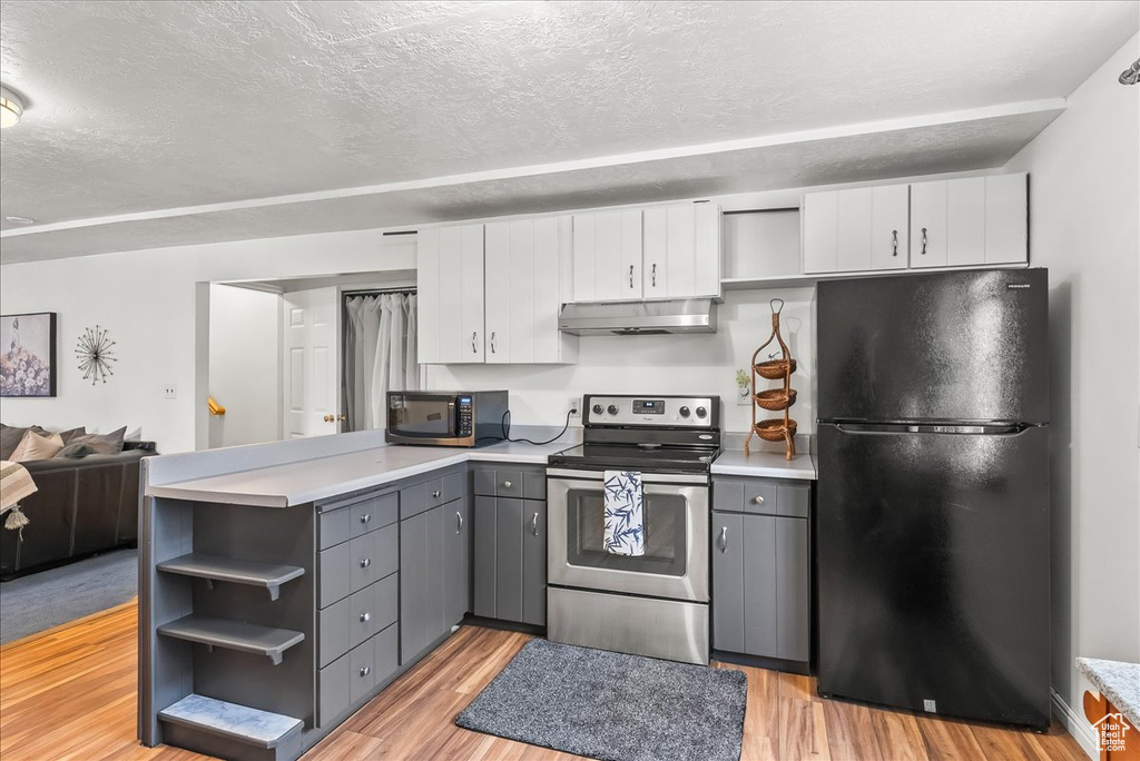 Kitchen featuring white cabinets, stainless steel appliances, gray cabinets, and light hardwood / wood-style floors