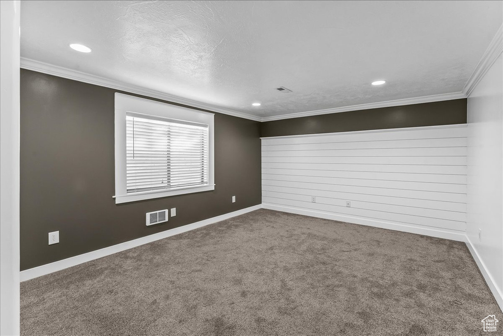 Unfurnished room with dark carpet and crown molding