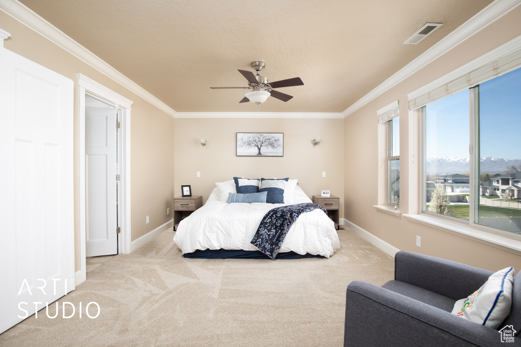 Bedroom featuring light colored carpet, ceiling fan, and crown molding