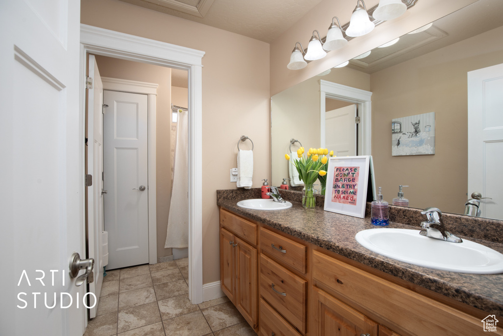 Bathroom with double vanity and tile flooring