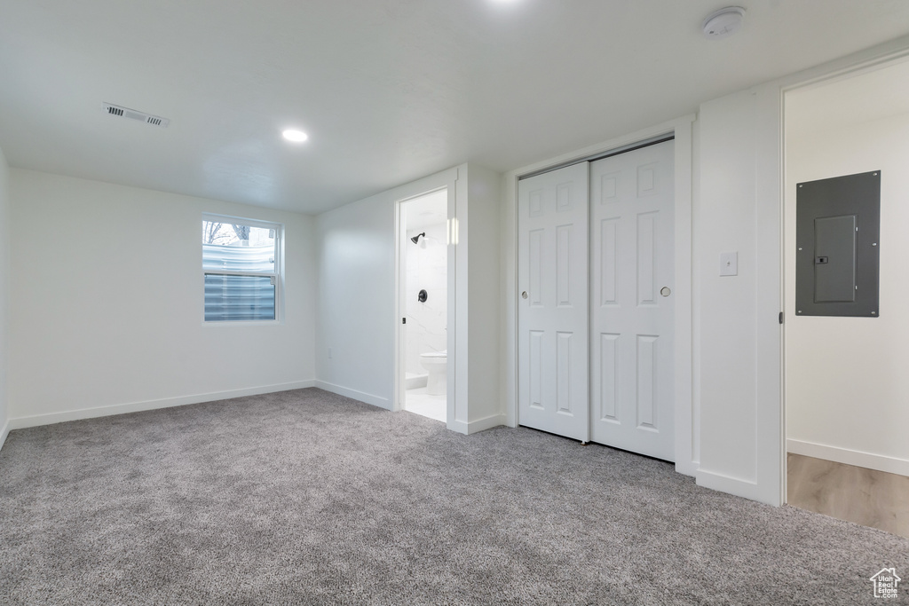 Unfurnished bedroom with light colored carpet, a closet, and ensuite bath