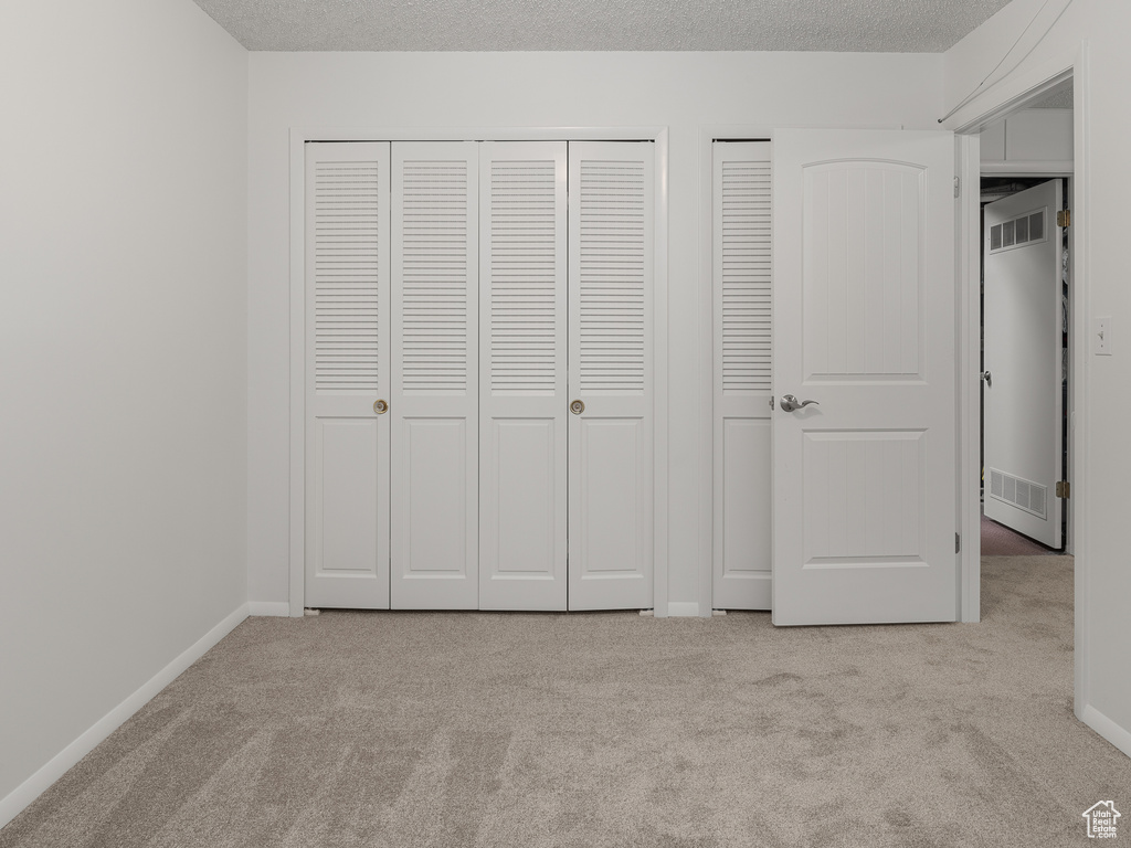 Unfurnished bedroom featuring two closets and light carpet