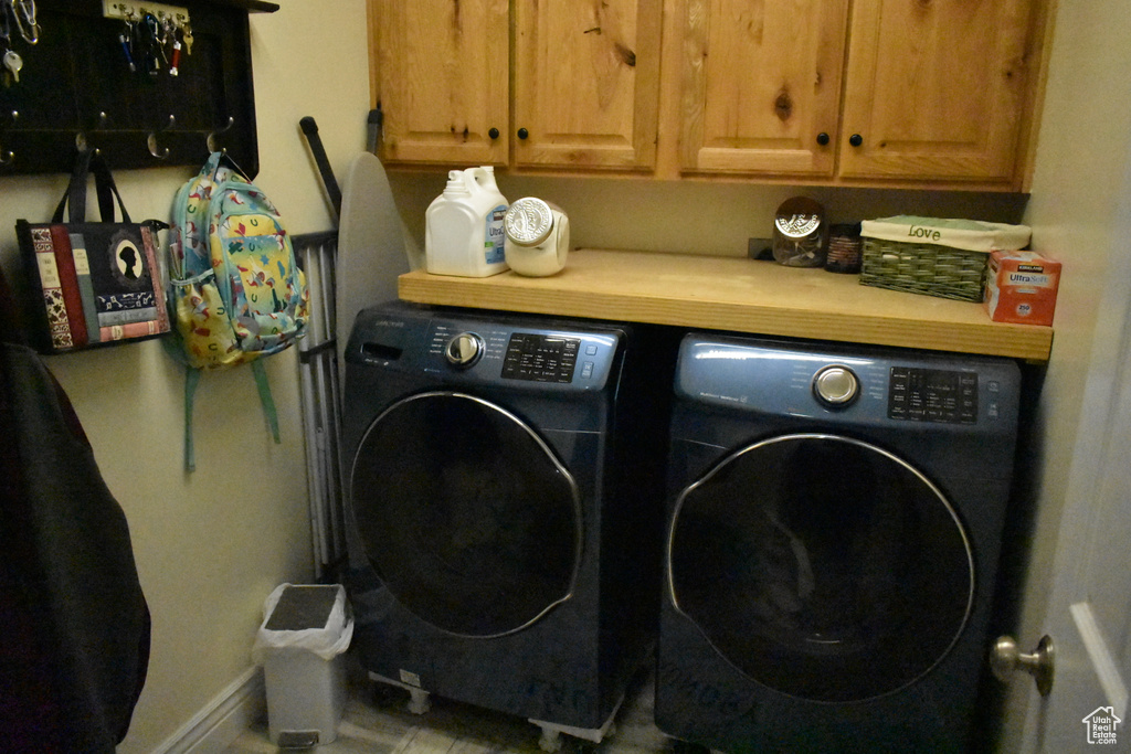 Washroom with cabinets and washer and dryer