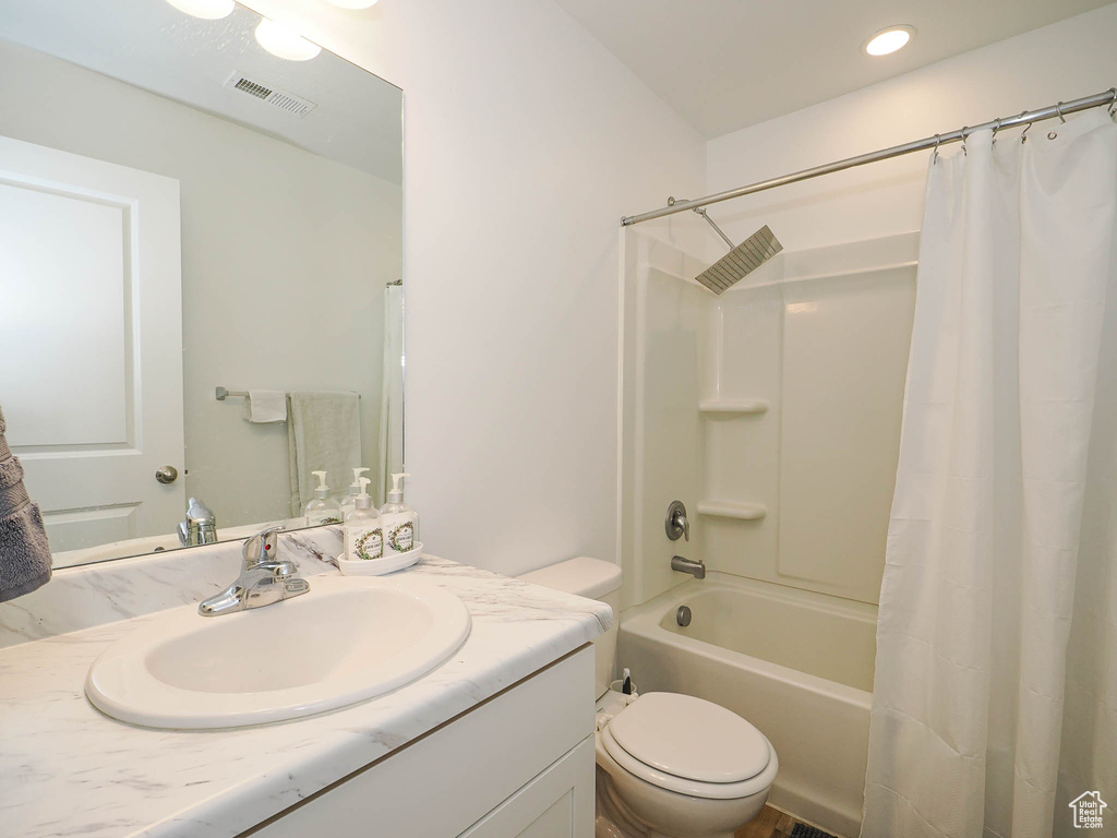 Full bathroom featuring vanity, toilet, and shower / tub combo